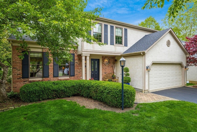 5584 Tangarey Ct, Columbus, OH 43235 - view of front of house with asphalt driveway, stucco siding, an attached garage, and a front yard