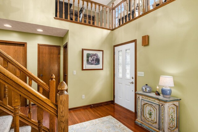 5584 Tangarey Ct, Columbus, OH 43235 - foyer entrance featuring wood finished floors, a towering ceiling, baseboards, stairs, and recessed lighting
