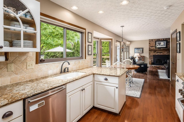 5584 Tangarey Ct, Columbus, OH 43235 - kitchen featuring dishwasher, a sink, white cabinetry, a textured ceiling, and backsplash