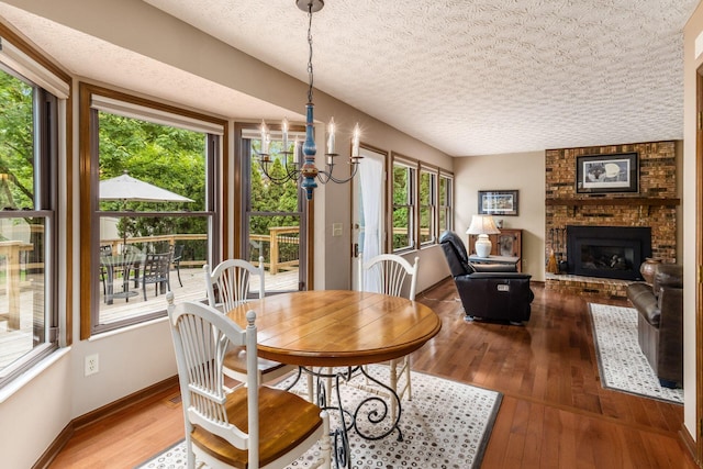 5584 Tangarey Ct, Columbus, OH 43235 - dining room featuring a fireplace, wood-type flooring, a textured ceiling, and baseboards