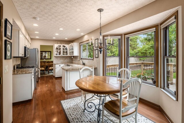 5584 Tangarey Ct, Columbus, OH 43235 - dining area with a chandelier, dark wood-style floors, recessed lighting, and baseboards