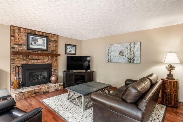 5584 Tangarey Ct, Columbus, OH 43235 - living room featuring wood finished floors, a textured ceiling, and a fireplace