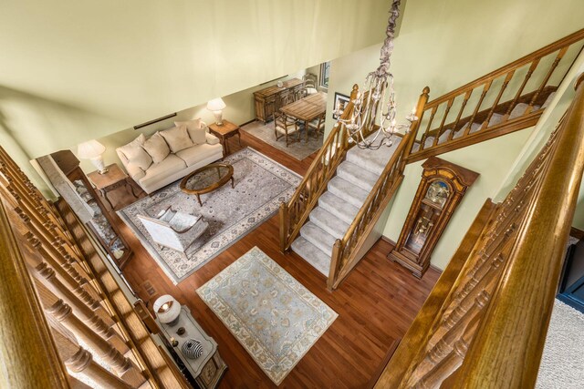 5584 Tangarey Ct, Columbus, OH 43235 - living area featuring stairs, wood finished floors, a chandelier, and baseboards