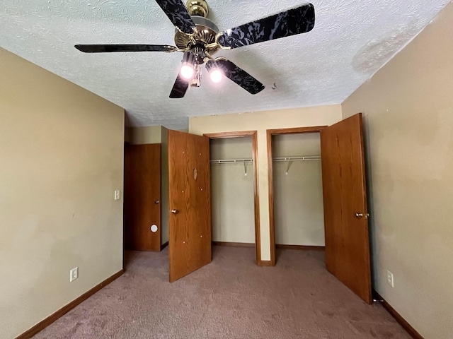 5459 Red Wynne Ln, Hilliard, OH 43026 - unfurnished bedroom with two closets, a textured ceiling, baseboards, carpet floors, and ceiling fan