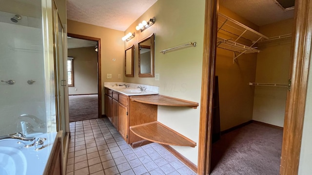 5459 Red Wynne Ln, Hilliard, OH 43026 - full bathroom featuring vanity, a shower with door, a spacious closet, a textured ceiling, and tile patterned flooring