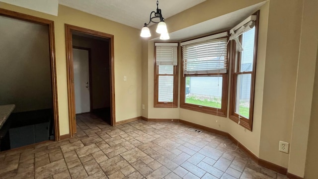 5459 Red Wynne Ln, Hilliard, OH 43026 - unfurnished dining area featuring stone tile flooring, baseboards, and a chandelier