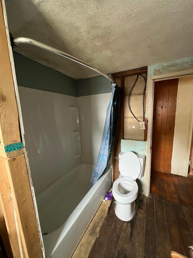 527 N 15th St, Coshocton, OH 43812 - bathroom with hardwood / wood-style flooring, toilet, shower / tub combo, and a textured ceiling