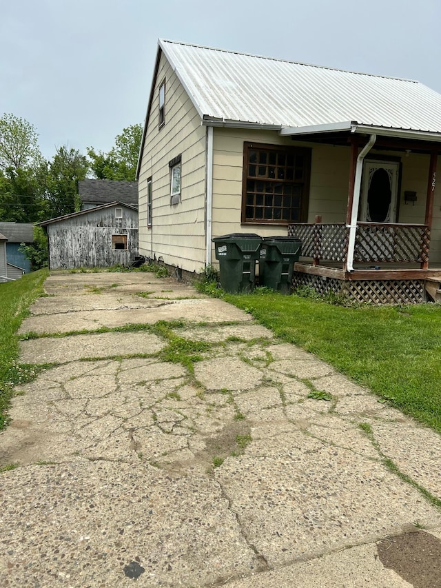 527 N 15th St, Coshocton, OH 43812 - view of home's exterior featuring covered porch, metal roof, and driveway