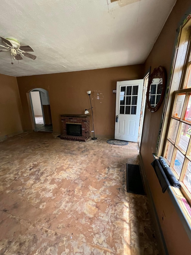 527 N 15th St, Coshocton, OH 43812 - unfurnished living room featuring arched walkways, a brick fireplace, and a ceiling fan