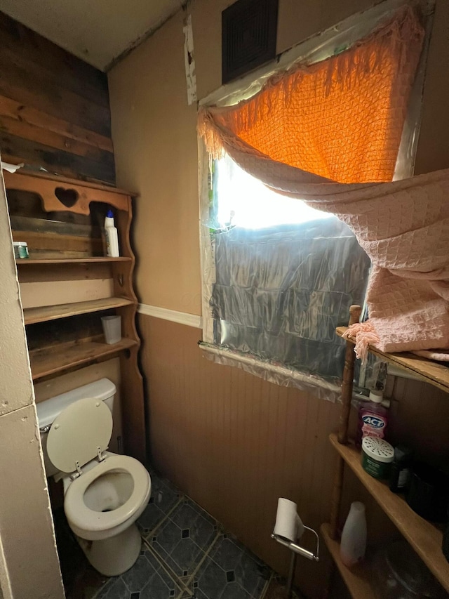 527 N 15th St, Coshocton, OH 43812 - bathroom featuring wooden walls, wainscoting, toilet, and tile patterned floors