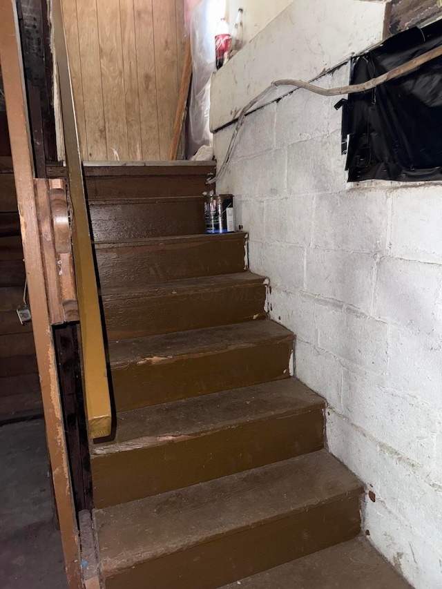 527 N 15th St, Coshocton, OH 43812 - staircase with concrete block wall and unfinished concrete floors