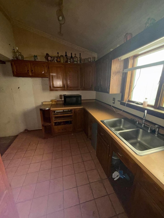 527 N 15th St, Coshocton, OH 43812 - kitchen with black microwave, vaulted ceiling, a sink, light tile patterned floors, and light countertops