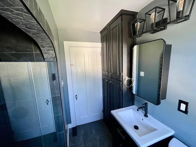 221 S Sylvan Ave, Columbus, OH 43204 - bathroom featuring vanity, toilet, and a tile shower