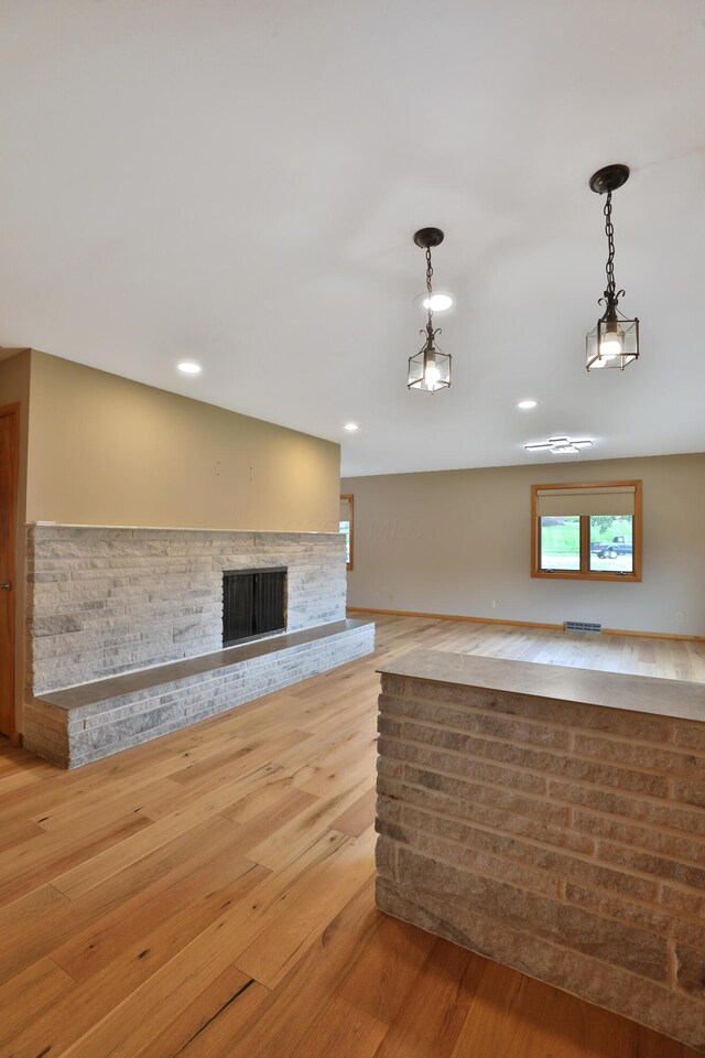 465 W Schrock Rd, Westerville, OH 43081 - kitchen with hanging light fixtures, light wood-style floors, a fireplace with raised hearth, and recessed lighting