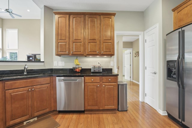 8708 Belworth Sq, New Albany, OH 43054 - kitchen featuring appliances with stainless steel finishes, a sink, light wood-style floors, a ceiling fan, and dark stone counters