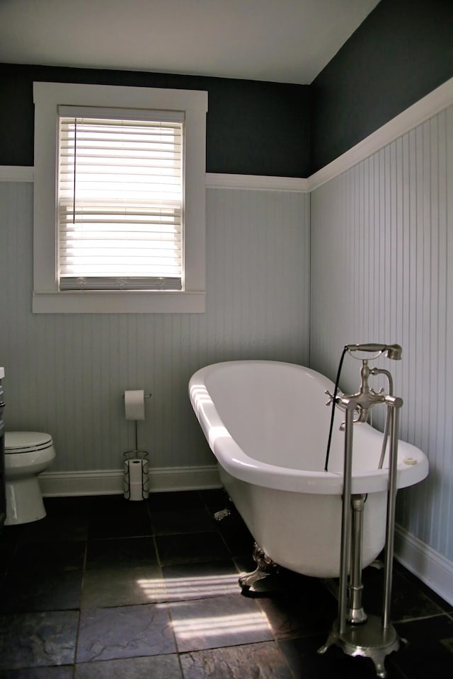 632 E 5th Ave, Lancaster, OH 43130 - full bathroom with a freestanding tub, baseboards, toilet, tile patterned flooring, and wainscoting