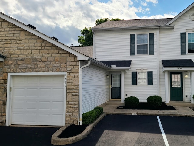 6768 Axtel Dr Unit 15B, Canal Winchester, OH 43110 - view of front of house with stone siding, a shingled roof, and an attached garage