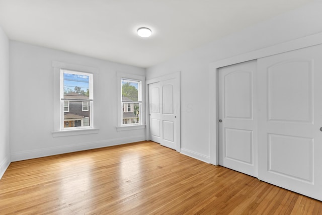 429 S Champion Ave, Columbus, OH 43205 - unfurnished bedroom featuring two closets, light wood-type flooring, and baseboards