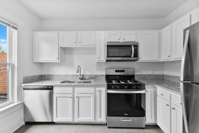 429 S Champion Ave, Columbus, OH 43205 - kitchen featuring appliances with stainless steel finishes, a sink, white cabinetry, and light stone countertops