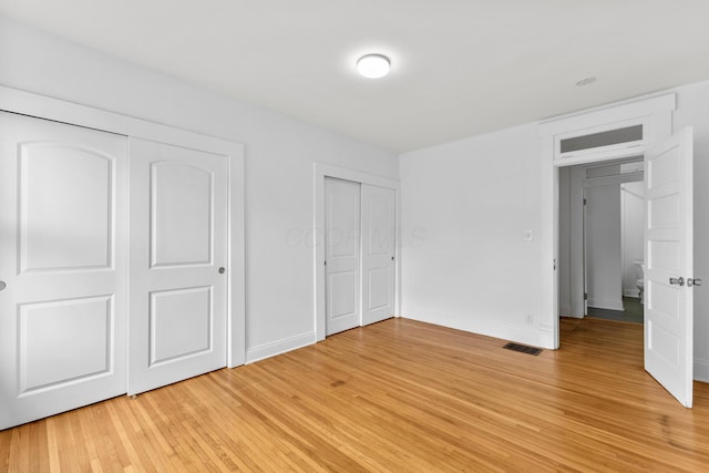 429 S Champion Ave, Columbus, OH 43205 - unfurnished bedroom with light wood-type flooring, baseboards, and multiple closets