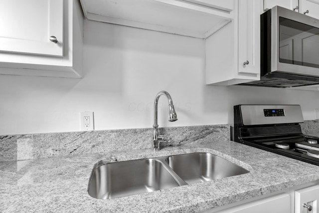 429 S Champion Ave, Columbus, OH 43205 - kitchen view of appliances with stainless steel finishes, a sink, white cabinets, and light stone counters