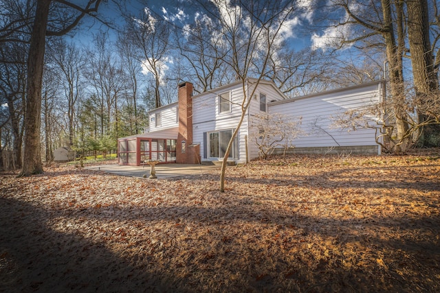 213 Kokosing Dr, Gambier, OH 43022 - view of side of home with a chimney, a patio area, and a sunroom