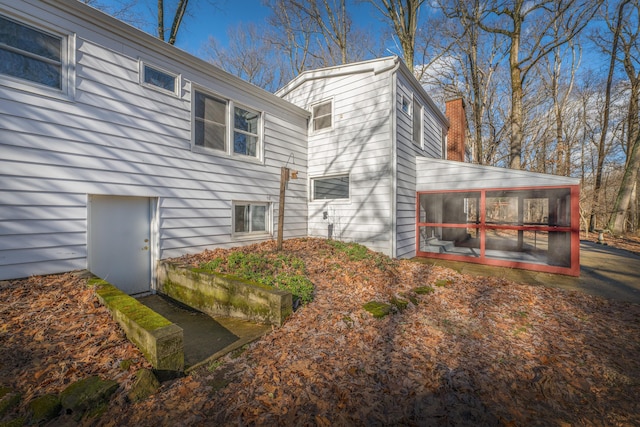 213 Kokosing Dr, Gambier, OH 43022 - view of side of home featuring a sunroom and a chimney