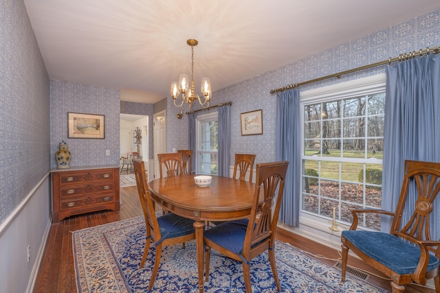 213 Kokosing Dr, Gambier, OH 43022 - dining area featuring wood finished floors, a chandelier, wallpapered walls, and baseboards