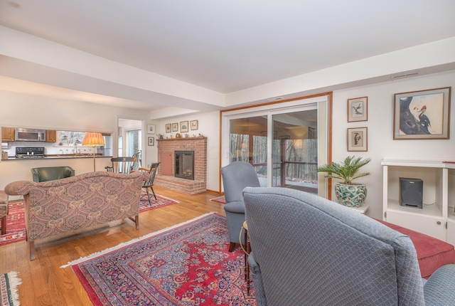 213 Kokosing Dr, Gambier, OH 43022 - living room featuring healthy amount of natural light, light wood-type flooring, and a brick fireplace