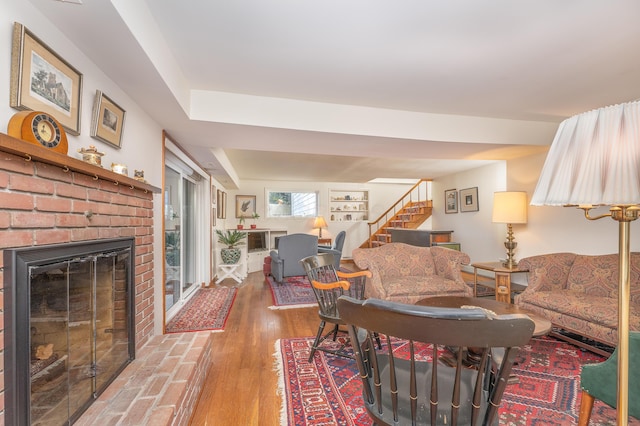 213 Kokosing Dr, Gambier, OH 43022 - living area with stairs, wood finished floors, and a brick fireplace