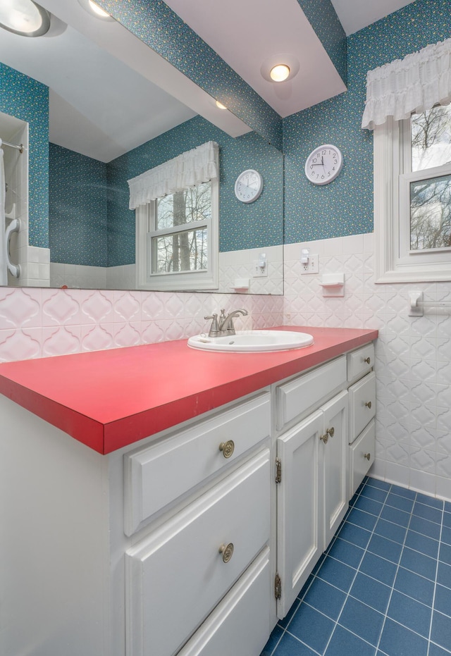 213 Kokosing Dr, Gambier, OH 43022 - bathroom with tile patterned flooring, vanity, tile walls, and a wainscoted wall