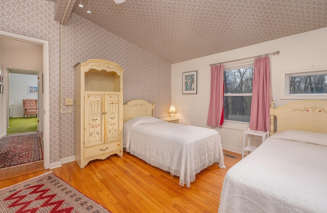 213 Kokosing Dr, Gambier, OH 43022 - bedroom featuring light wood-type flooring, wallpapered walls, vaulted ceiling, and baseboards