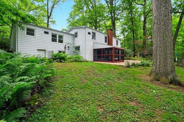 213 Kokosing Dr, Gambier, OH 43022 - back of property featuring a sunroom, a chimney, and a yard