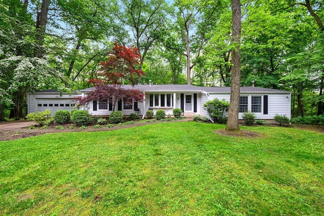 213 Kokosing Dr, Gambier, OH 43022 - ranch-style home featuring a garage, driveway, a front lawn, and view of wooded area