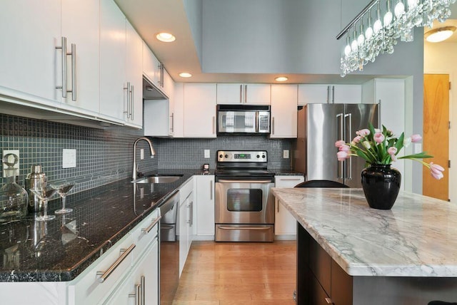 110 N 3rd St Unit 709, Columbus, OH 43215 - kitchen featuring appliances with stainless steel finishes, a sink, light wood finished floors, tasteful backsplash, and recessed lighting