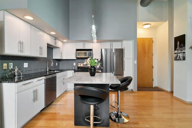 110 N 3rd St Unit 709, Columbus, OH 43215 - kitchen featuring stainless steel appliances, a sink, a kitchen breakfast bar, white cabinets, and a kitchen island