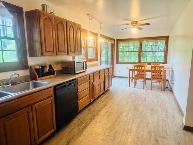 91 Bridle Path Ln, Granville, OH 43023 - kitchen with dishwasher, stainless steel microwave, a sink, light wood-style floors, and brown cabinets