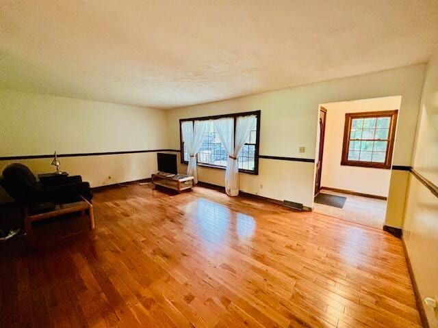 91 Bridle Path Ln, Granville, OH 43023 - unfurnished living room featuring wood finished floors, plenty of natural light, and baseboards