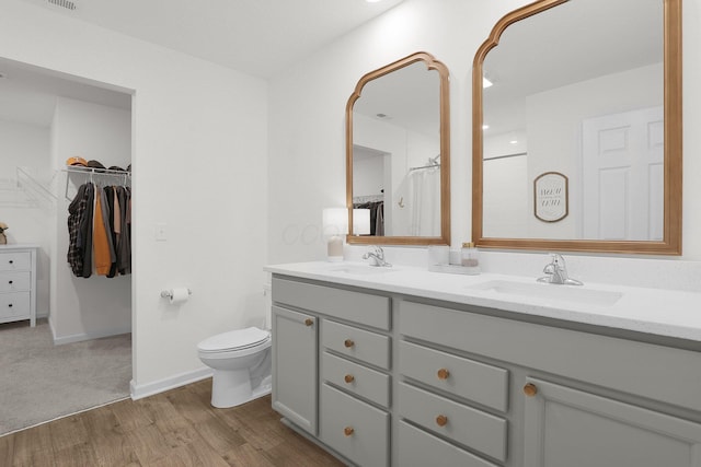 417 Bren Dr, Lancaster, OH 43130 - bathroom featuring double vanity, toilet, wood finished floors, and a walk in closet