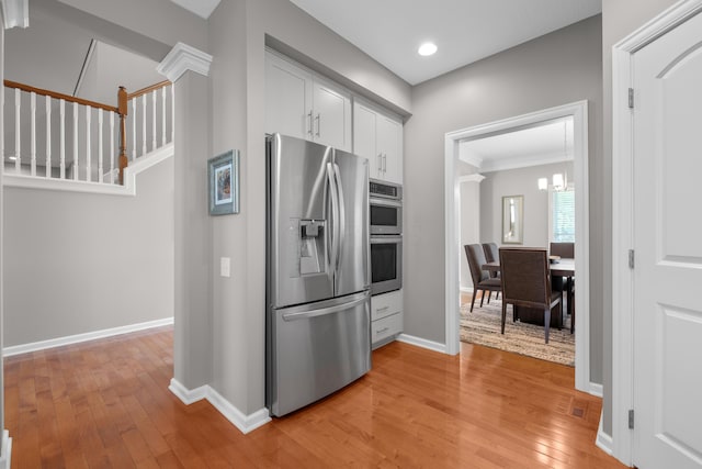 6655 Baronscourt Loop, Dublin, OH 43016 - kitchen featuring appliances with stainless steel finishes, light wood-style floors, baseboards, recessed lighting, and ornamental molding