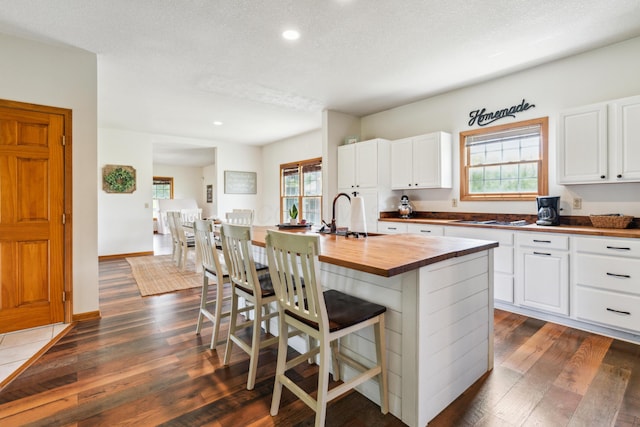 17994 Claypool Rd SE, Newark, OH 43056 - kitchen with wood counters, a sink, dark wood-style flooring, stovetop, and a breakfast bar