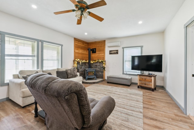 17994 Claypool Rd SE, Newark, OH 43056 - living area with a wall mounted AC, a wood stove, a ceiling fan, light wood-type flooring, and recessed lighting