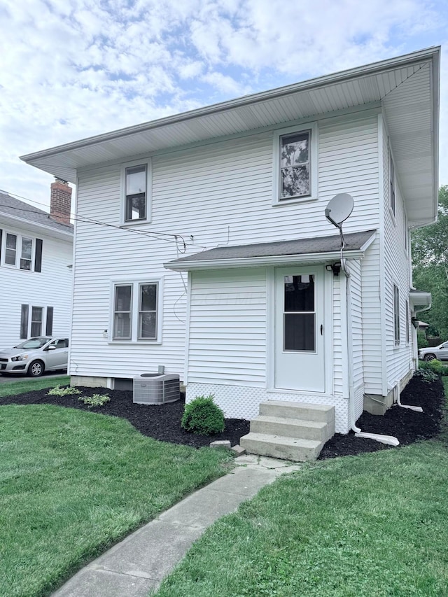 84 E 5th St, London, OH 43140 - rear view of house with entry steps, central air condition unit, and a lawn