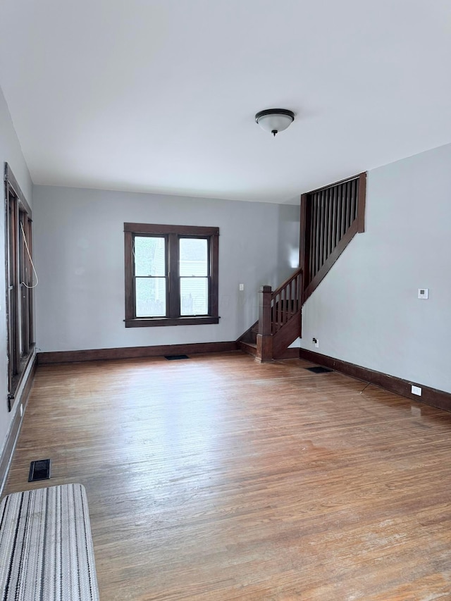 84 E 5th St, London, OH 43140 - unfurnished living room with stairway, wood finished floors, and baseboards
