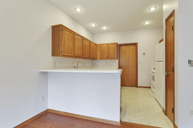 7706 Redman Ln, Reynoldsburg, OH 43068 - kitchen with a peninsula, light countertops, brown cabinets, recessed lighting, and baseboards