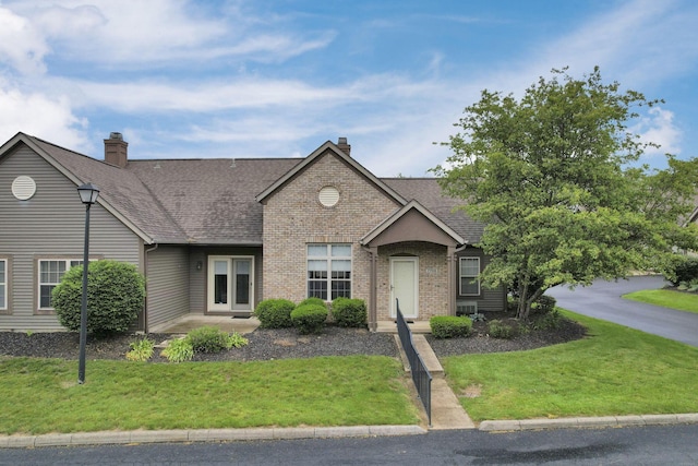 7706 Redman Ln, Reynoldsburg, OH 43068 - view of front facade featuring a chimney, a front lawn, roof with shingles, and brick siding