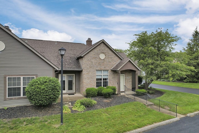 7706 Redman Ln, Reynoldsburg, OH 43068 - view of front of home featuring a front lawn, brick siding, a chimney, and roof with shingles