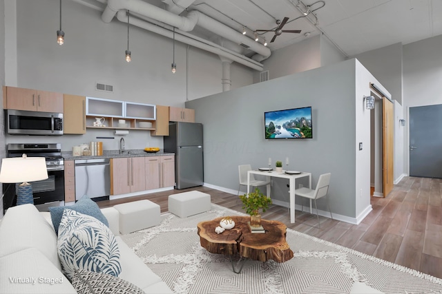 60 E Spring St Unit 327, Columbus, OH 43215 - living room featuring a high ceiling, baseboards, and light wood-style flooring