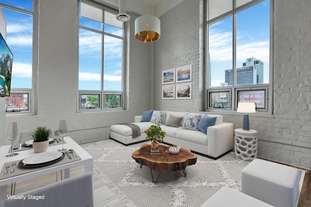 60 E Spring St Unit 327, Columbus, OH 43215 - living room with healthy amount of natural light, wood finished floors, and brick wall