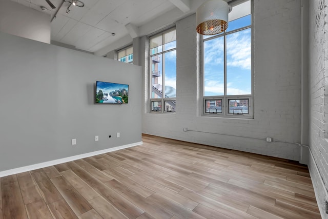 60 E Spring St Unit 327, Columbus, OH 43215 - spare room featuring light wood-type flooring and brick wall